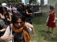 Турецкий полицейский использует слезоточивый газ против женщины в первый день турецких протестов (Reuters)