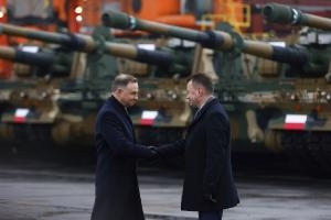 Президент Польши Анджей Дуда (слева) и министр обороны Мариуш Блащак приветствуют в порту Гдыни первую поставку танков и гаубиц из Южной Кореи, отмечая быстрое выполнение сделки, подписанной летом перед лицом войны на Украине, 6 декабря 2022 года.